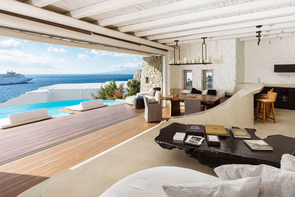 Cavo Tagoo Santorini luxury suite in Imerovigli featuring expansive indoor-outdoor living, private terrace with plunge pool, horizon-edge caldera views, and contemporary five-star interior design overlooking the Aegean Sea.