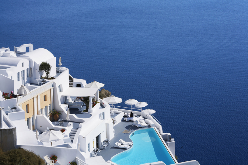 Katikies Santorini luxury hotel in Oia perched on the caldera cliffs with infinity pool, white Cycladic architecture, and panoramic Aegean Sea views.
