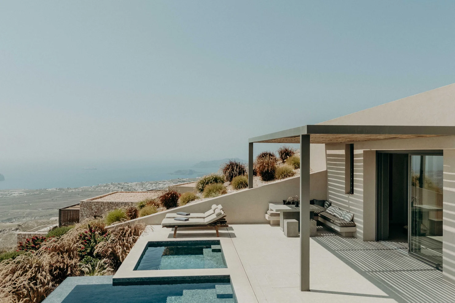 Santorini Sky Hotel luxury private villa near Pyrgos with heated plunge pool, modern minimalist design, expansive terrace, and panoramic Aegean Sea views from Santorini’s highest elevation.