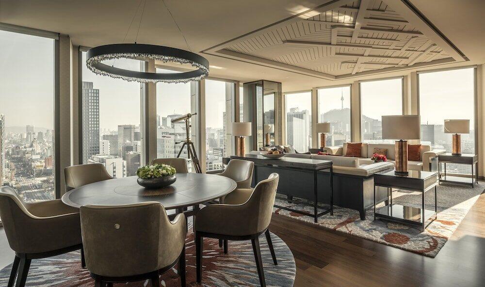 Four Seasons Hotel Seoul luxury suite featuring spacious living area, floor-to-ceiling windows, and panoramic city views, highlighting five-star accommodations at one of the top luxury hotels in Seoul South Korea.