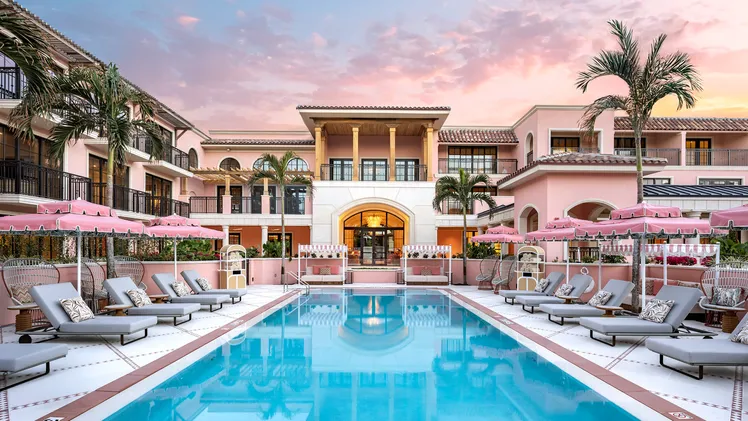 Luxury oceanfront resort at The Breakers Palm Beach featuring palm-lined pools, a private beach, and classic Mediterranean Revival architecture overlooking the Atlantic Ocean.