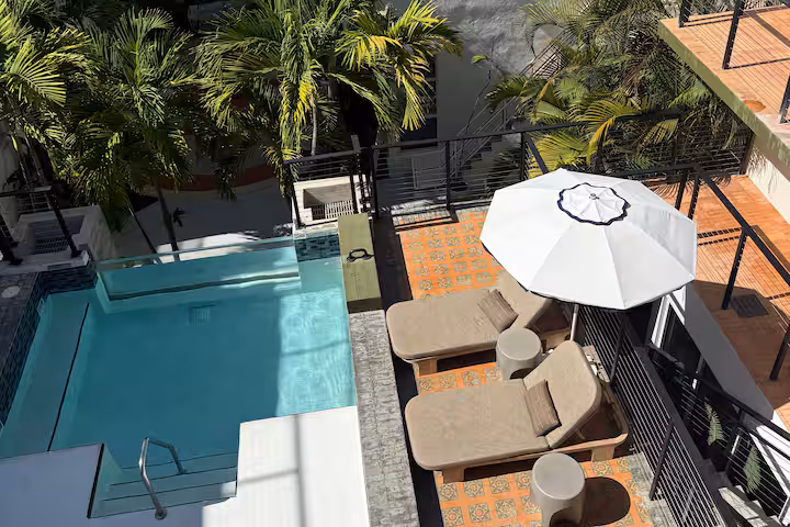 The Balfour Hotel Miami Beach boutique hotel on Ocean Drive with mid-century modern rooms, Frette linens, marble bathrooms, palm-lined courtyard plunge pool, and dedicated beach access with loungers and attentive service.