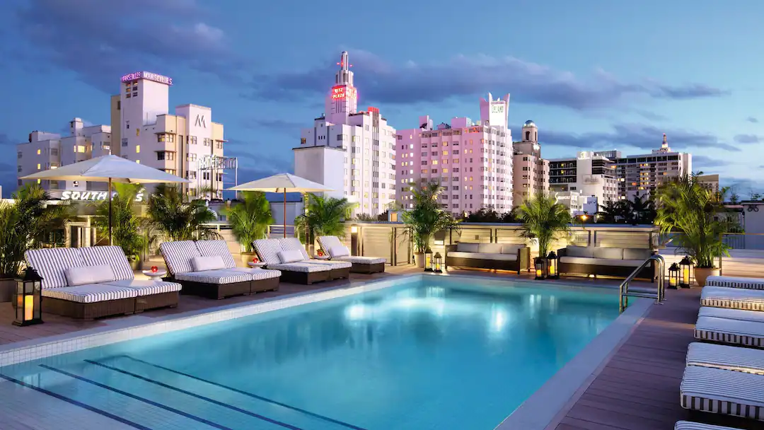 Rooftop pool and modern guest room at Uma House Miami Beach with ocean-view terraces, Malin + Goetz amenities, private beach access with loungers, and relaxed South Beach boutique hotel design near Collins Avenue.