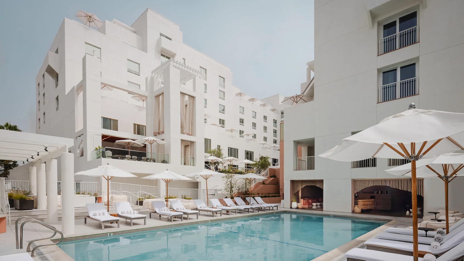 Pool deck at Sandbourne Santa Monica with cabanas and white modern architecture, showcasing one of the top Boutique Hotels Santa Monica and Boutique Hotels Los Angeles for travelers researching where to stay in Los Angeles. Santa Monica Boutique Hotels | Boutique Hotels Los Angeles | Luxury Hotels in Los Angeles | Santa Monica Luxury hotels | Boutique Hotels LA | Where to stay in Los Angeles | Los Angeles Luxury Boutique Hotel | Santa Monica hotel on the Beach | Best Luxury Boutique Hotels Santa Monica | Top Hotels in Santa Monica | Jetset Select