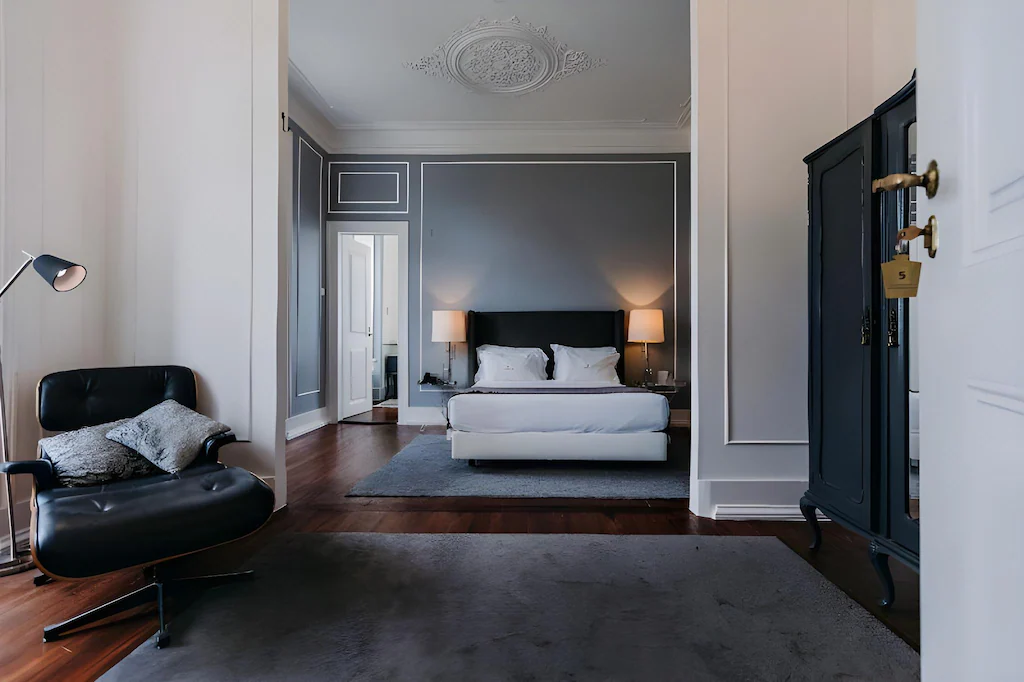 A spacious luxury hotel room at Torel Palace Lisbon, featuring Michelin-star dining, contemporary design, plush king beds, velvet furnishings, high ceilings, and private balconies overlooking Lisbon rooftops and the Tagus River. Torel Palace Lisbon | Torel Palace Porto | Five Star Hotel in Porto | Porto Hotel | Torel Palace Lisbon Portugal | Luxury Hotels in Porto Portugal | Lisbon 5 Star Hotels | Luxury hotels Lisbon | Best Hotels in Lisbon | Where to stay in Lisbon.